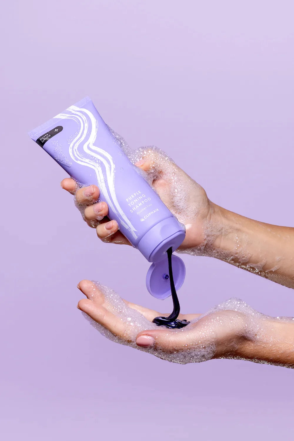 hand holding purple shampoo bottle